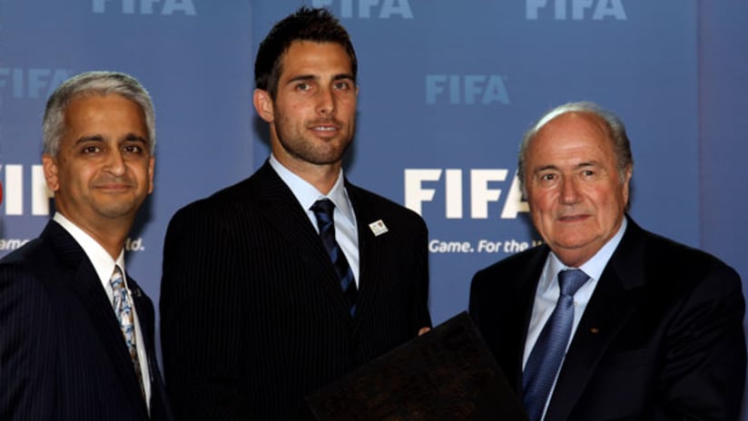 L-R: U.S. Soccer president Sunil Gulati and Carlos Bocanegra present the bid book to FIFA president Sepp Blatter.