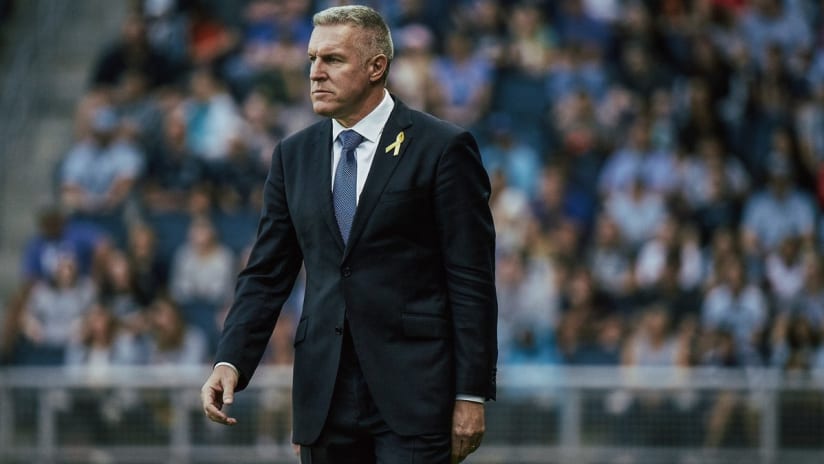Peter Vermes in a sharp suit on the sideline
