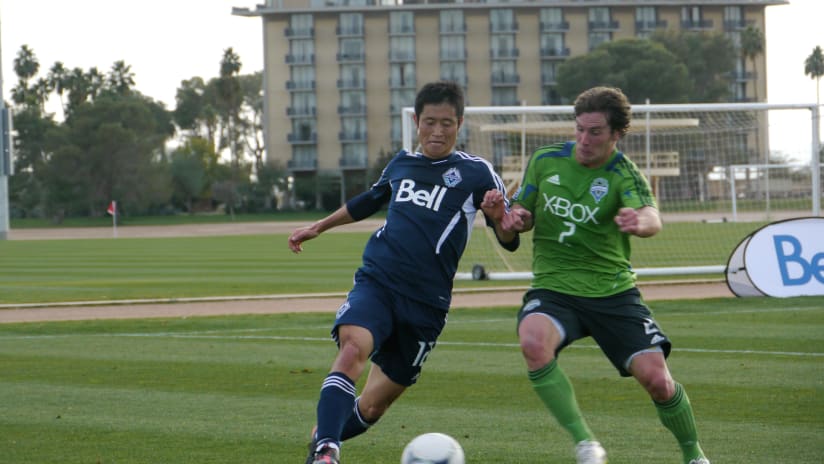 Whitecaps FC defender Young-Pyo Lee and Sounders FC striker Mike Fucito battle