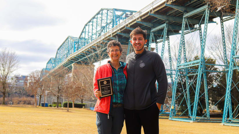 CFC Goalkeeper Jon Burke presents Mary Beth Sutton with January’s Community Hero of the Month