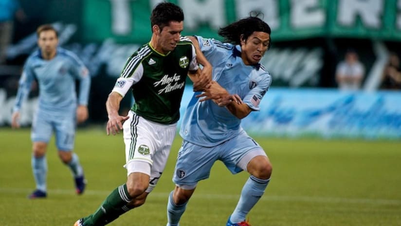 Steve Purdy of the Portland Timbers and Roger Espinoza of Sporting KC battle for the ball