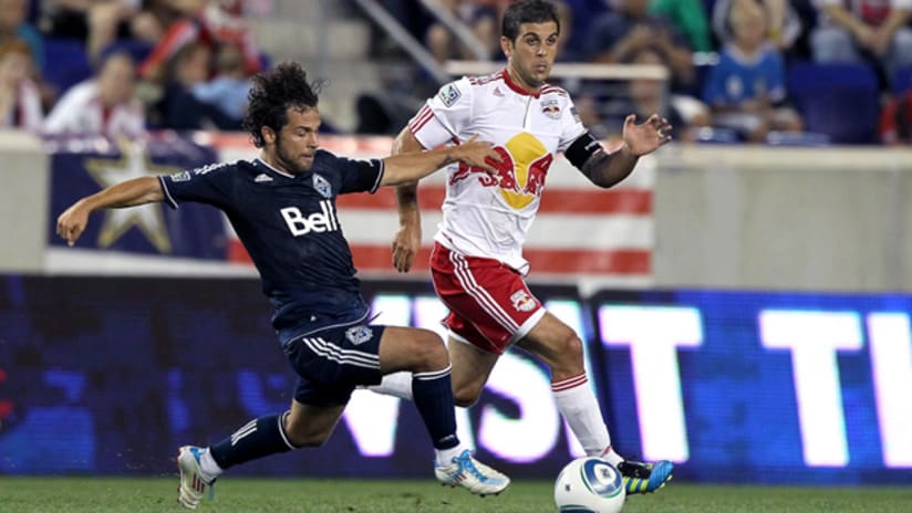 Whitecaps' Davide Chiumiento (left) tries to get by Red Bulls' Carlos Mendes