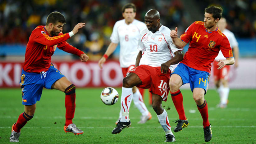 Blaise Nkufo, center, fights off a challenge from Spain's Gerard Pique and Xabi Alonso.