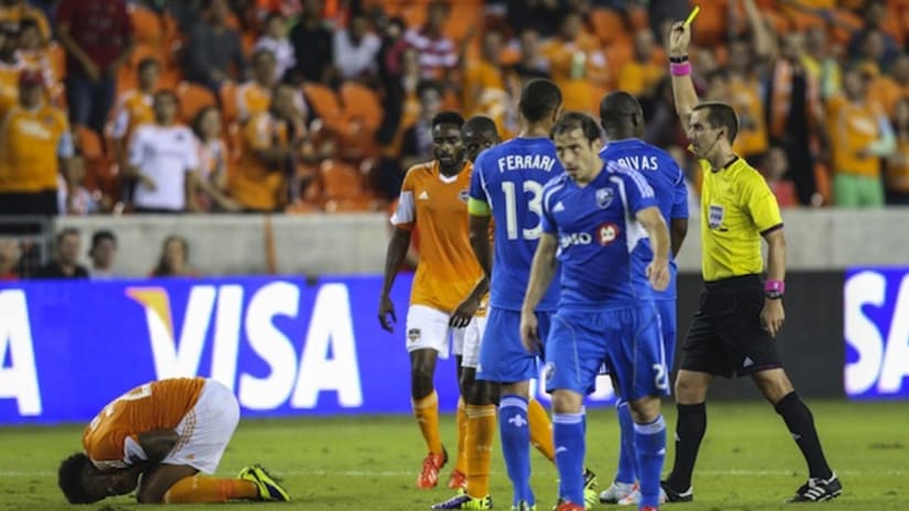 Mark Geiger shows a yellow card in the Houston Dynamo-Montreal Impact Knockout Round game