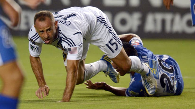 LA Galaxy's Laurent Courtois trips over an Isidro Metapan defender