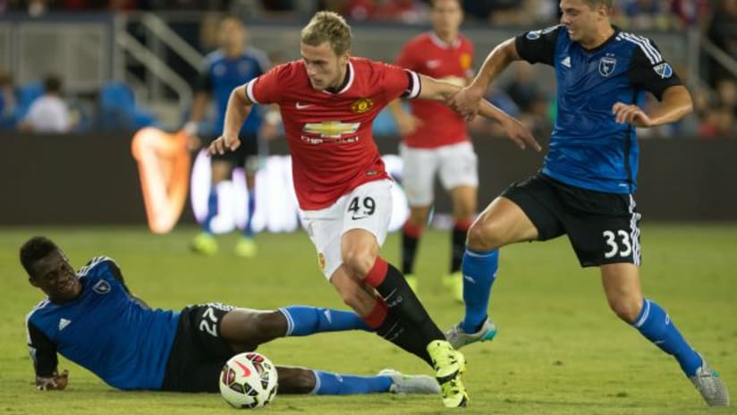 San Jose Earthquakes' Fatai Alashe goes in on Manchester United's Justin Wilson