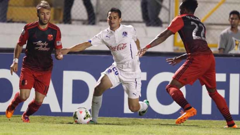 Gaston Fernandez and Rodney Wallace (Portland Timbers) defend against an Olimpia player in CCL