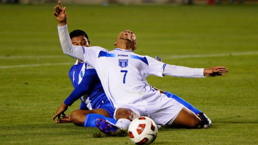 Emil Martinez of Honduras is scythed down by Carlos Castrillo of Guatemala