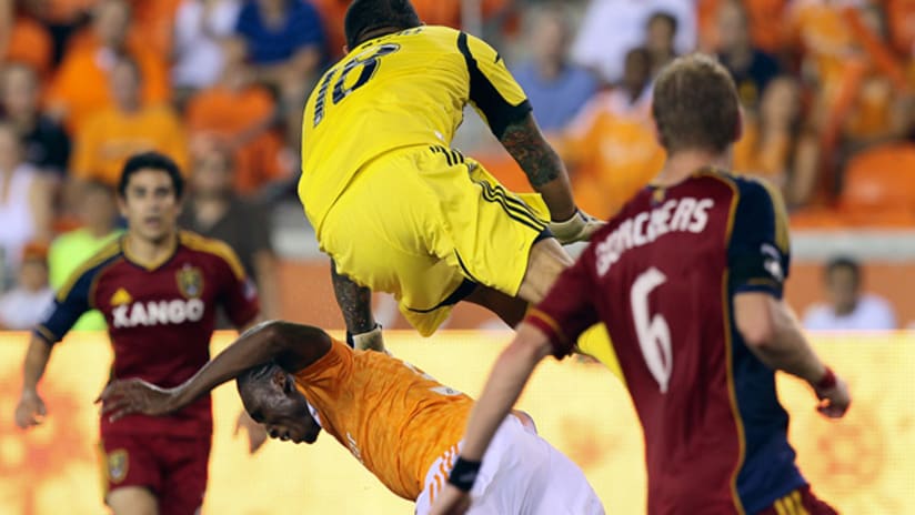RSL goalie Nick Rimando crashes into Houston's Mac Kandji as he attempts to clear a cross