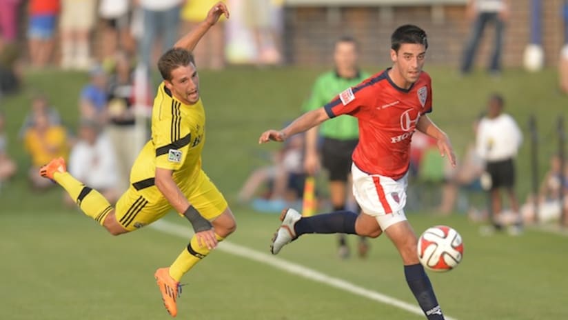 The Columbus Crew's Ethan Finlay is tripped by Indy Eleven's AJ Corrado