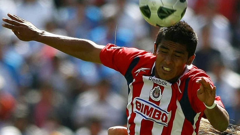 Chivas de Guadalajara left back Miguel Angel Ponce jumps to win an aerial ball.