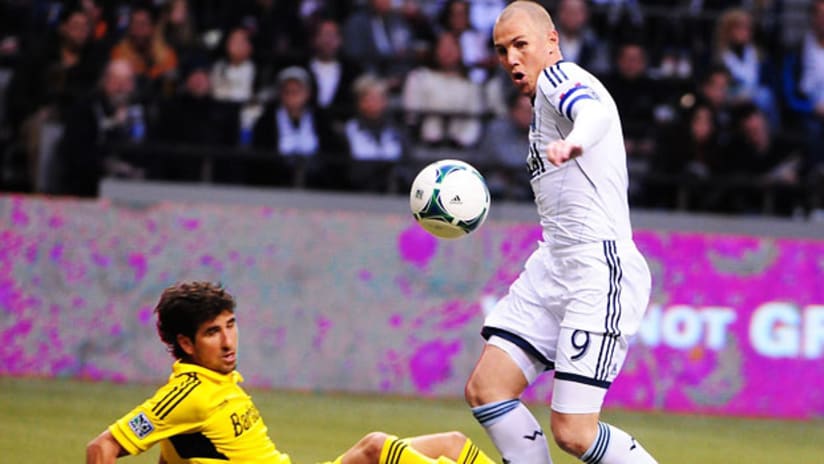 Kenny Miller, Vancouver Whitecaps, strips Columbus Crew's Glauber of the ball and goes in for a goal.