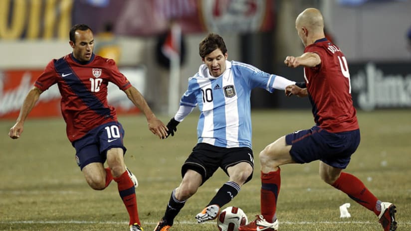 Landon Donovan (left) and Michael Bradley (right) close in on Lionel Messi (center).