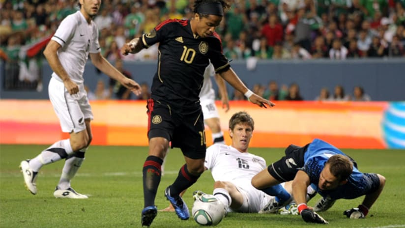 Giovani dos Santos dances around a defender and the goalie in Mexico's win over New Zealand.