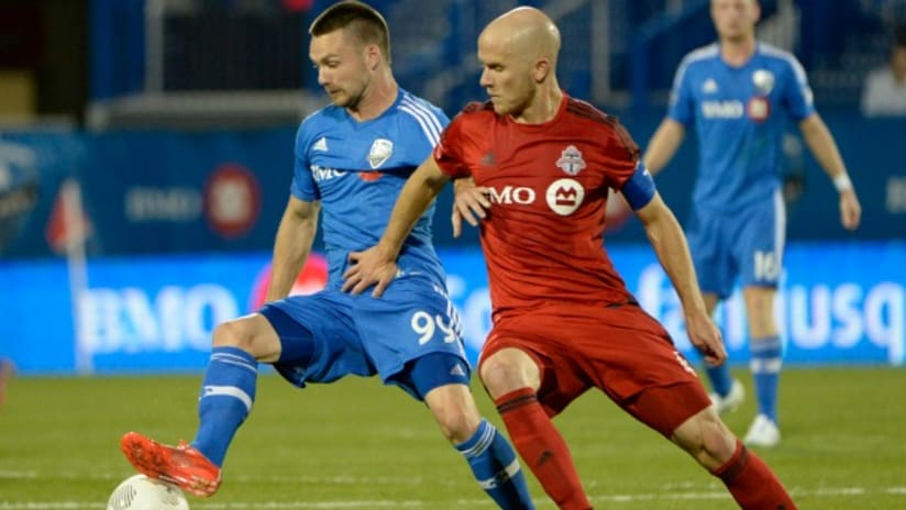 Jack McInerney (Montreal Impact) is tracked by Michael Bradley (Toronto FC)