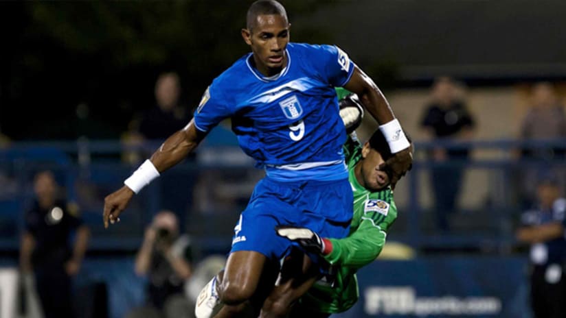 Honduras Jerry Bengston dribbles past Grenada goalie Shemel Louison.