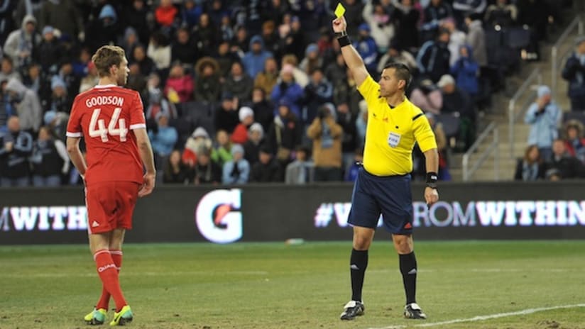 Clarence Goodson is shown a yellow card by Ricardo Salazar