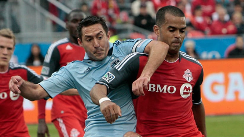 Sporting's Davy Arnaud (left) battles Toronto FC's Maicon Santos on Saturday night in Toronto.