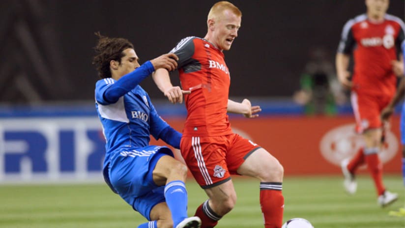 Toronto FC's Richard Eckersley fights for the ball with Montreal Impact's Bernardo Corradi