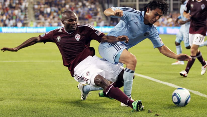 Colorado's omar cummings and Sporting's Roger Espinoza race for the ball.