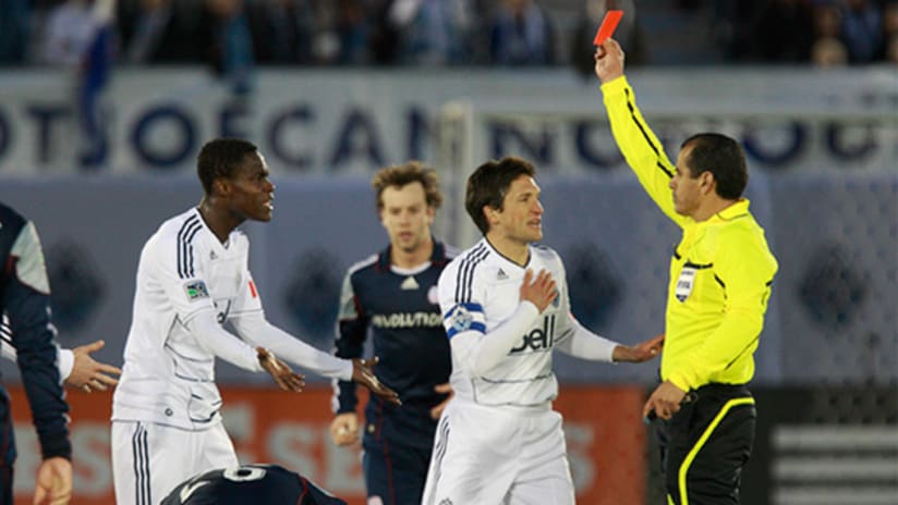 Vancouver's Gerhson Koffie (left) gets a red card during the Whitecaps' 1-1 draw against New England.