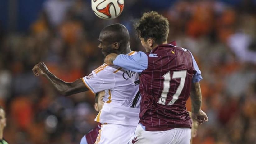 Houston Dynamo's Omar Cummings battles Aston Villa's Chris Herd for a header.