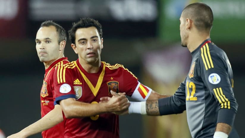 Spain's Xavi celebrates with Victor Valdes and Andres Iniesta