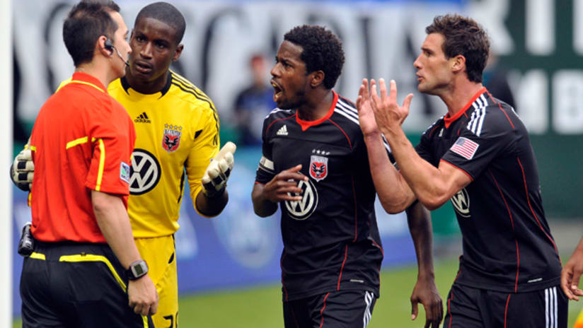 DC United complain to the referee after he orders the Portland Timbers to retake a PK.