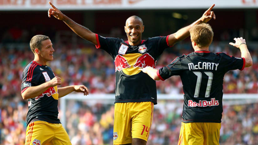 New York's Thierry Henry celebrates with teammates Dax McCarty and John Rooney.