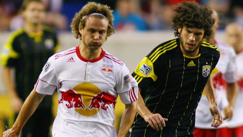 Stephen Keel of the New York Red Bulls plays the ball while being pursued by Tommy Heinemann of the Columbus Crew.