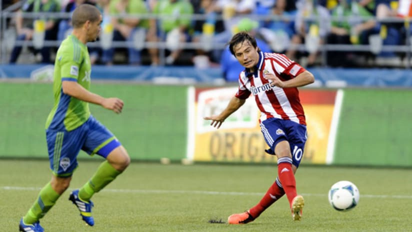 Chivas USA's Erick "Cubo" Torres shoots as Seattle's Osvaldo Alonso looks on