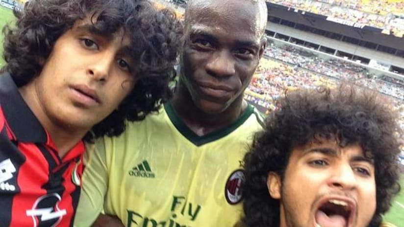 Mario Balotelli poses for selfie with two fans on the field during game