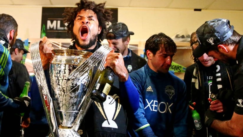 Roman Torres - MLS Cup - holding trophy - locker room - celebration - Seattle Sounders