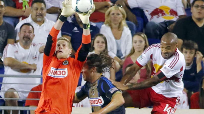 Philadelphia's Zac MacMath makes a save as Jeff Parke and New York's Thierry Henry challenge