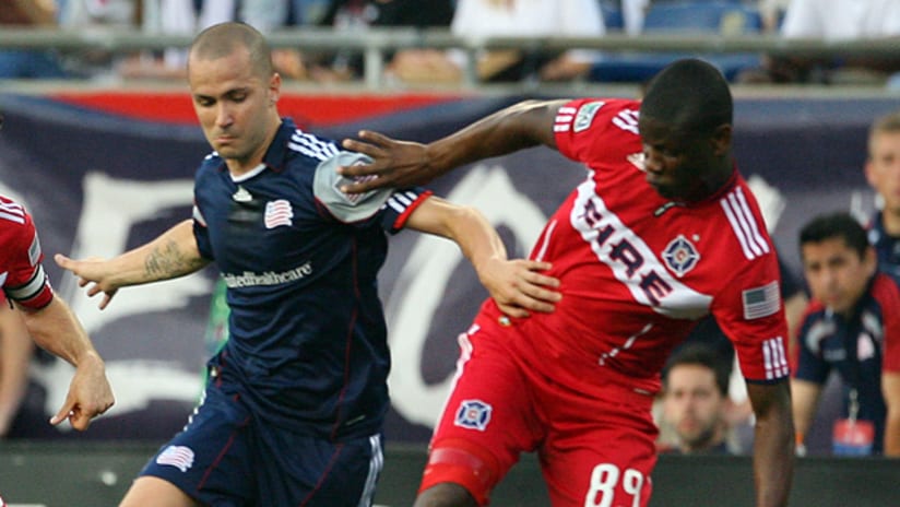 Rajko Lekic of the New England Revolution dribbles through Logan Pause and Yamirth Cuesta of the Chicago Fire.