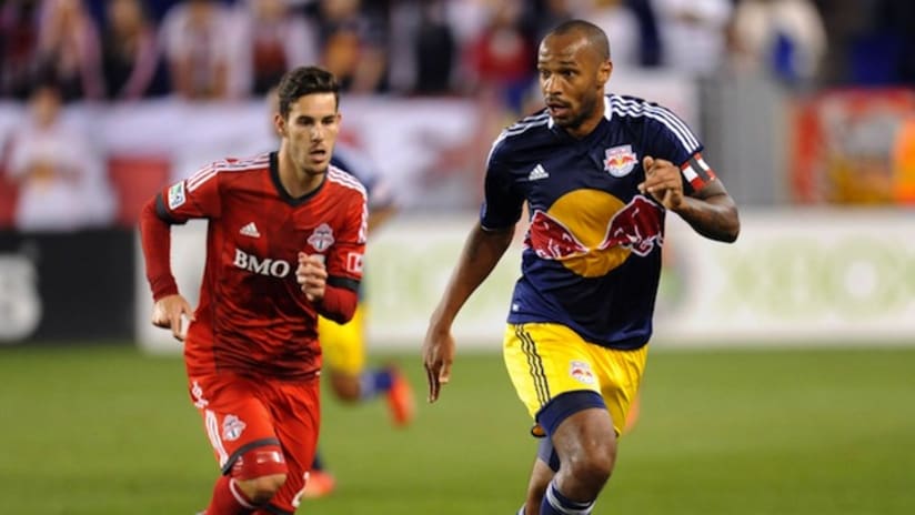 Thierry Henry takes the ball past a Toronto FC player