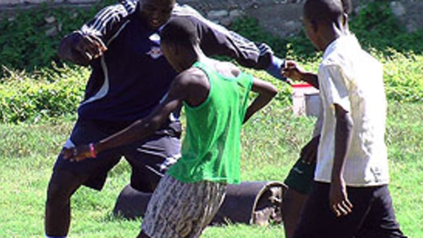 El joven Josmer Altidore juega con los menores haitianos durante la gira humanitaria.