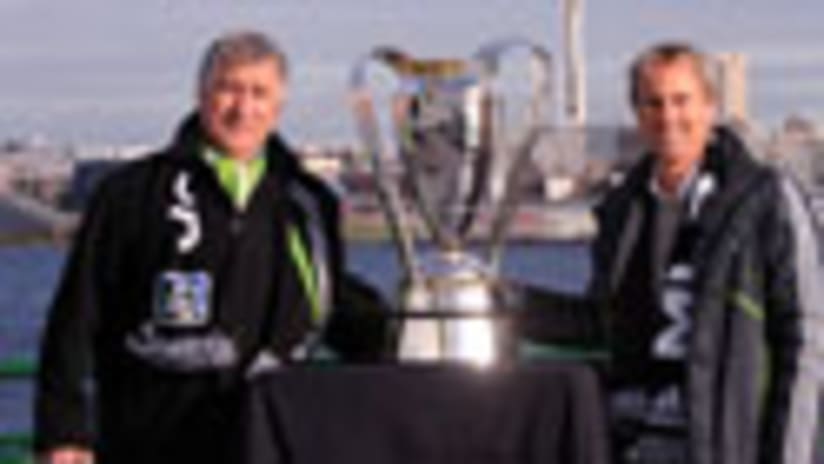 Sigi Schmid (left) and Chris Henderson welcome the Anschutz Trophy to Seattle.