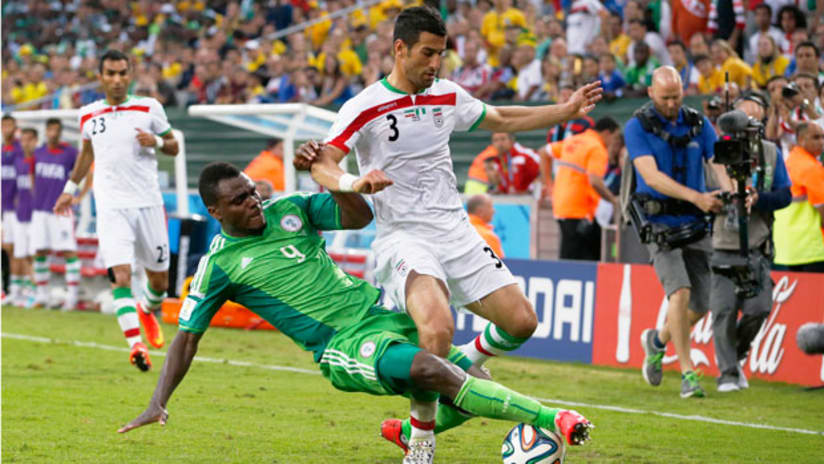 Iran's Ehsan Hajsafi (R) in action with Nigeria's Emmanuel Emenike