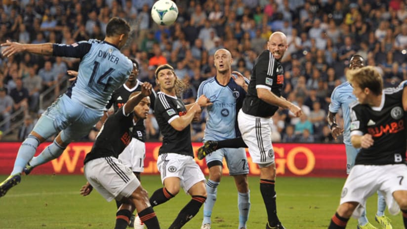 Dom Dwyer heads a ball on goal, Conor Casey looks on