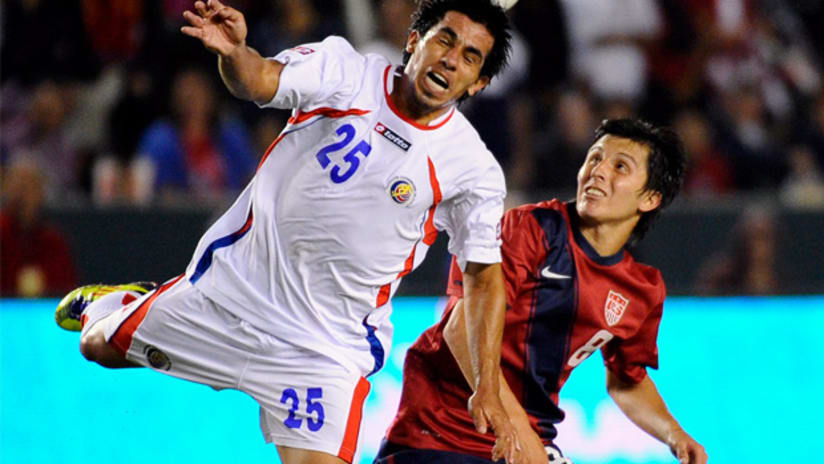 US' Jose Torres watches as Costa Rica's Alavaro Sanchez heads the ball away.