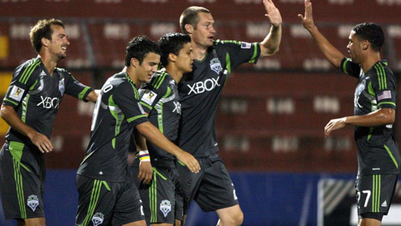 Seattle's Fredy Montero (center) celebrates his goal vs. Herediano with his teammates.