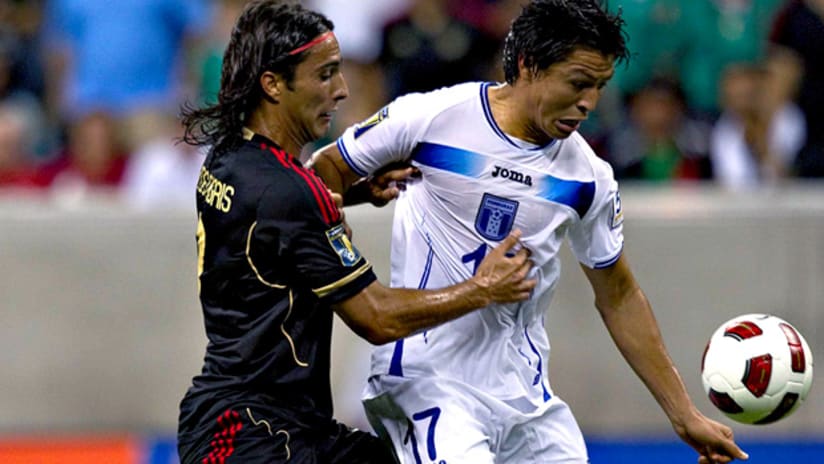 Mexico's Aldo de Nigris and Honduras' Roger Espinoza vie for the ball.