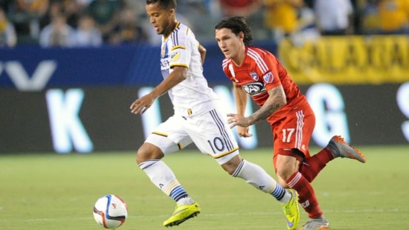 Giovani Dos Santos (LA Galaxy) moves the ball against FC Dallas defender Zach Loyd