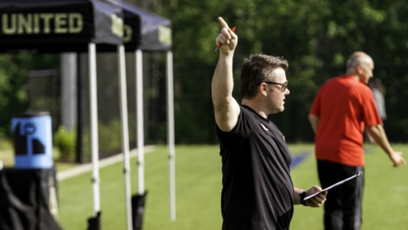 Atlanta United academy manager Tony Annan - holding a clipboard and pointing