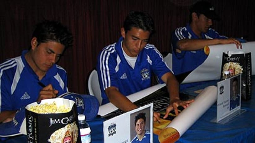 Brett Rodriguez, Orlando Ramirez and Brian Ching sign autographs.