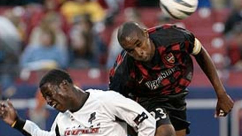 Eddie Johnson (left) and Eddie Pope battle for the ball Saturday.
