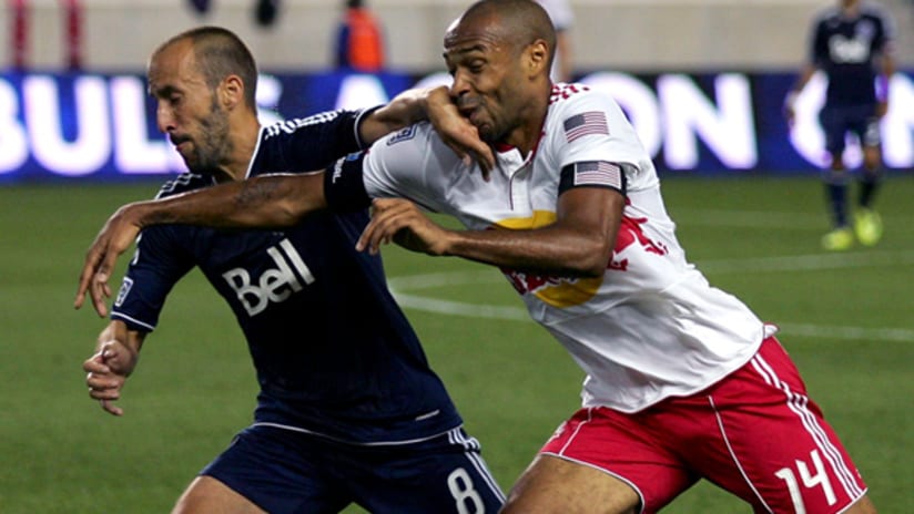 New York's Thierry Henry (right) vies for the ball vs. Vancouver's Peter Vagenas.