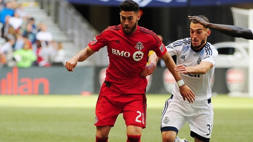 Toronto FC's Jonathan Osorio battles Vancouver Whitecaps FC's Russell Teibert