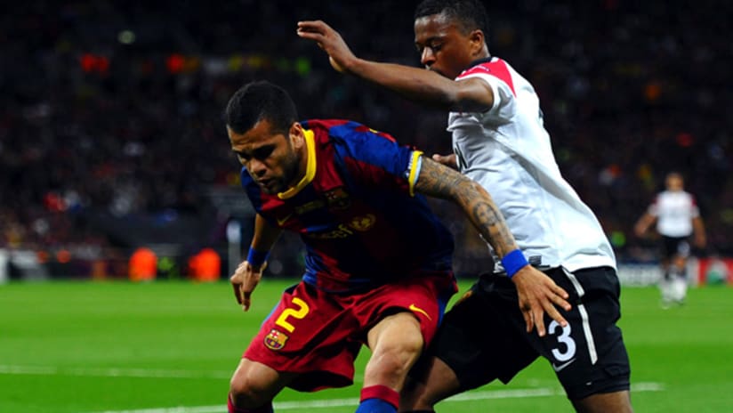 Barcelona's Dani Alves (left) shields the ball from Man. United's Patrice Evra.